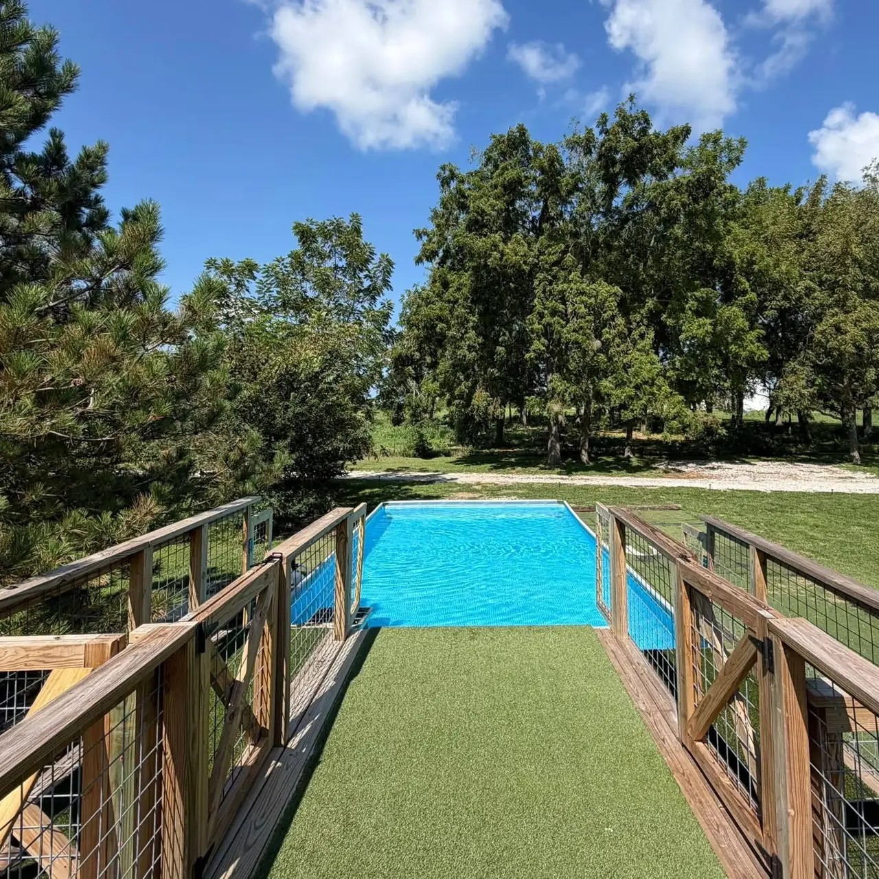 View down the dock diving runway toward the pool under a bright blue Missouri sky